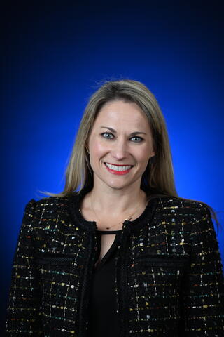 A woman with blonde hair in front of a blue background